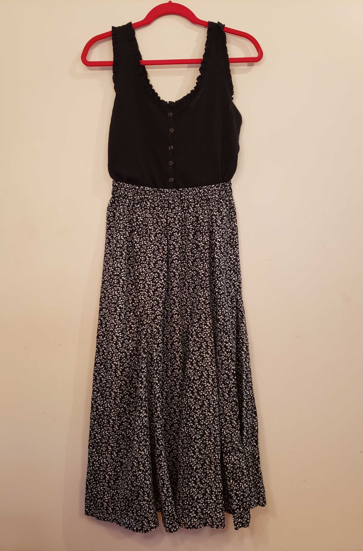 A tank top and a flower-print midi skirt hang on display